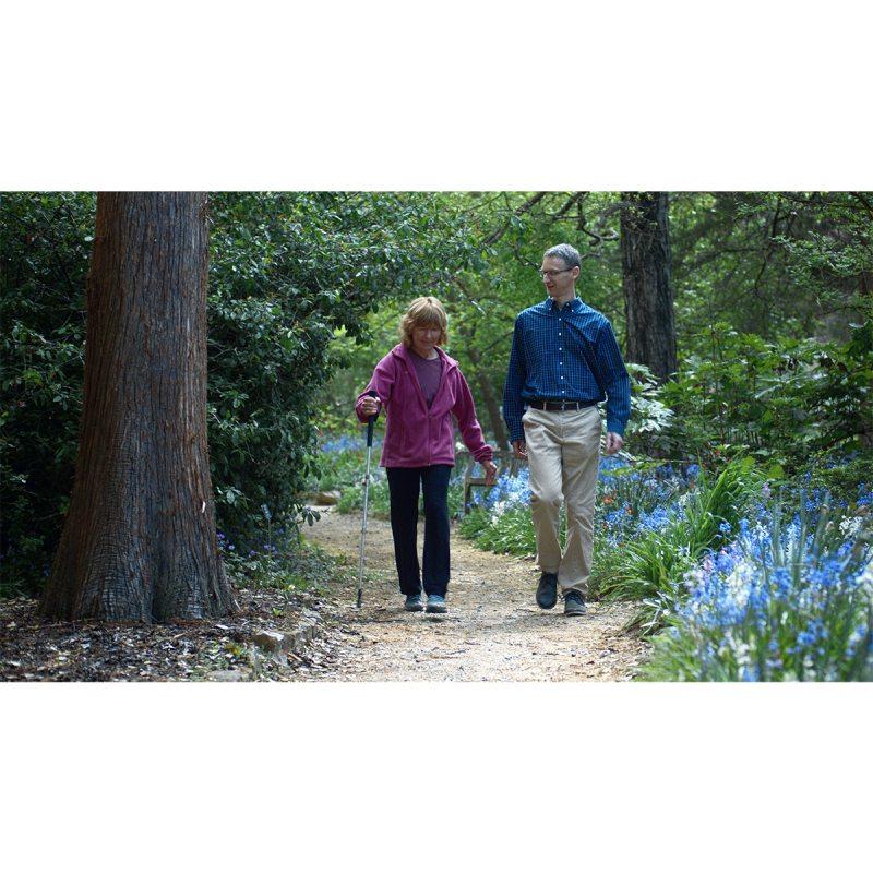 A researcher, Michael Lewek, walking on a nature trail with a patient.