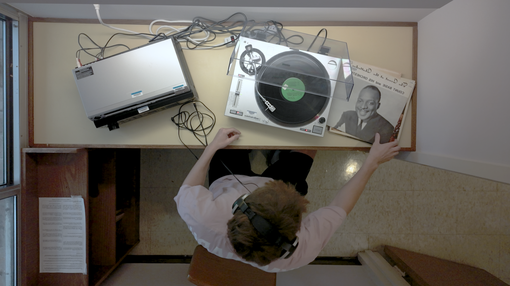 Bird's eye view of man sitting with record player.