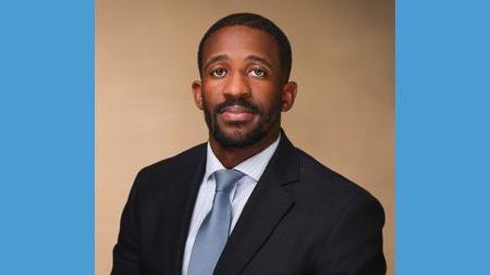 Headshot of Kenny Harris wearing suit.